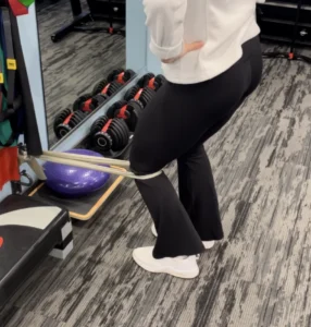 Athlete performing resistance band leg exercise at Burlington physiotherapy clinic for injury prevention