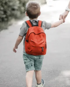Child walking to school with backpack highlighting posture and back health concerns